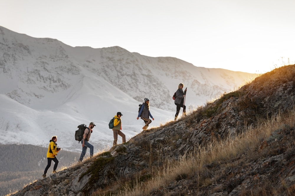 Hikers ascending a mountain trail at sunrise